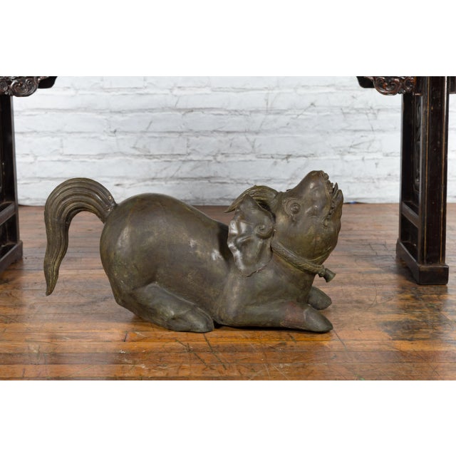 An Indonesian hand-tooled metal sculpture from the Celebes Island depicting a temple monster with swine ears and legs,...