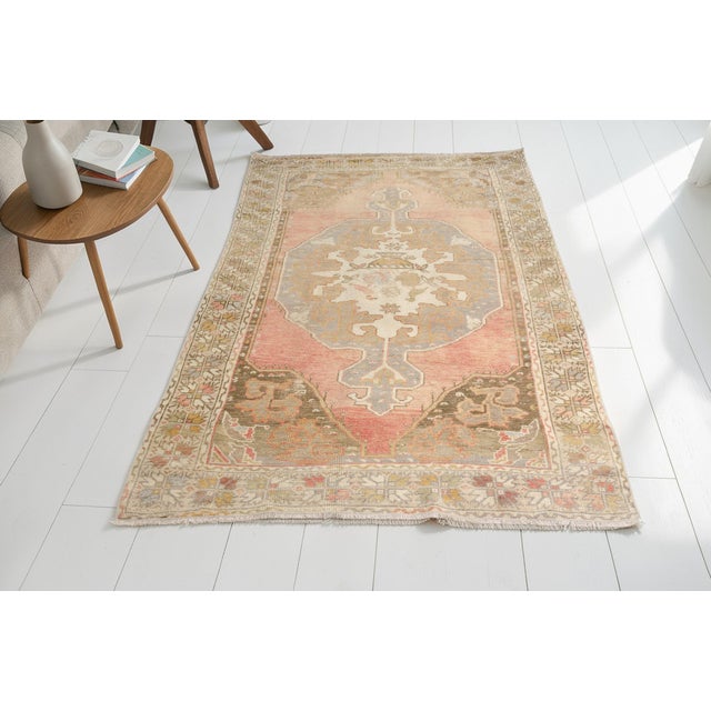This is a vintage Turkish Oushak rug from the Mid 20th Century. The piece was hand-knotted.