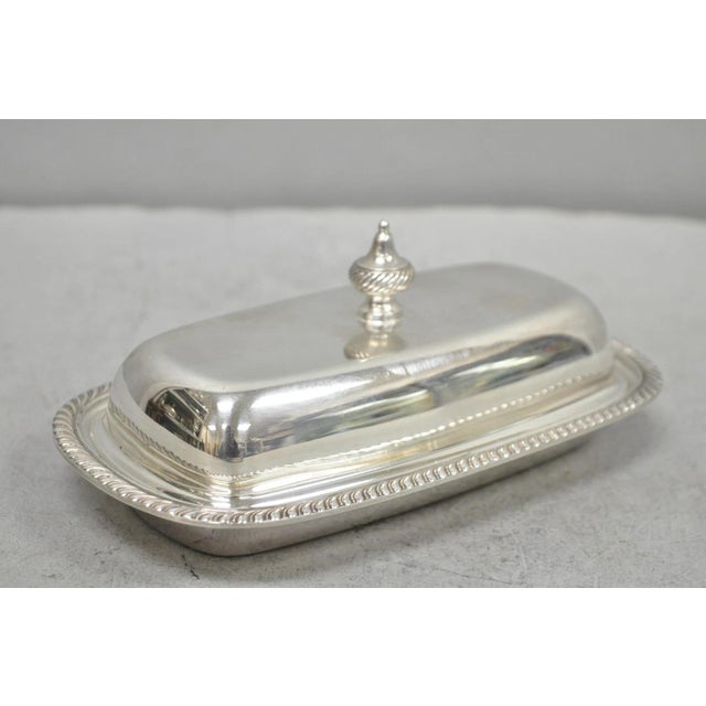 Vintage Oneida Silver Plated Covered Butter Dish w/ Glass Liner (A). Circa Mid 20th Century. Measurements: 3" H x 7.5" W x...