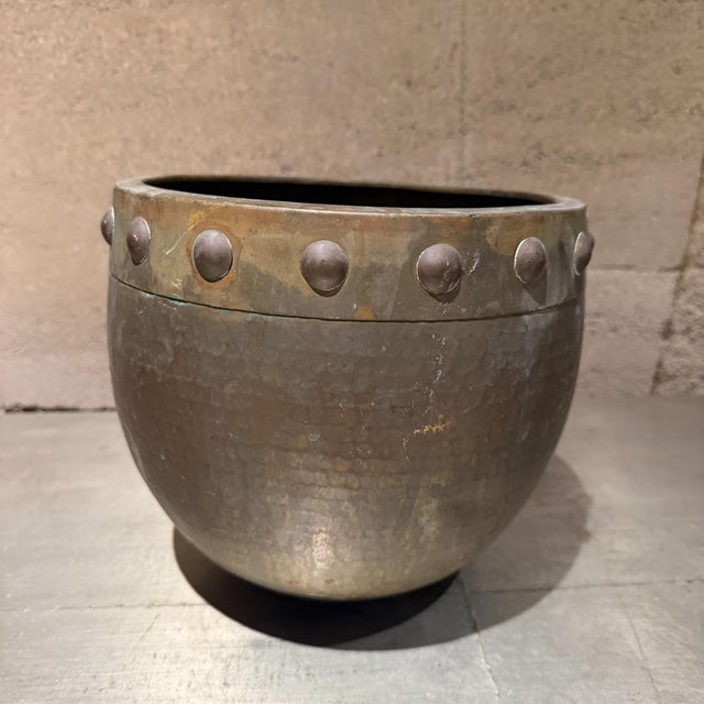 For your consideration, a vintage hammered brass or copper planter/jardiniere featuring a prominent riveted rim band....