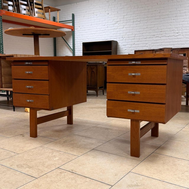 Vintage mid-century Danish modern teak executive desk. Features include a bank of three drawers and slide-out surface on...
