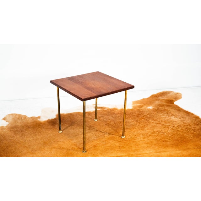 Vintage Danish Modern teak side table with metal legs by John Stuart for France & Søn, circa 1960s. Brass legs attached to...