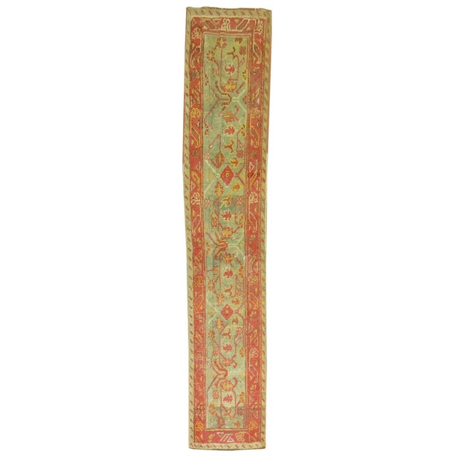 A rare size early 20th century antique Oushak runner in sage green and warm terracotta accents. Measures: 1'9" x 8'4".