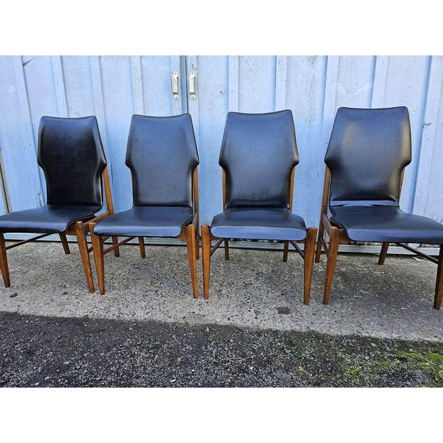 Four Lane Mid Century Modern First Edition Walnut Black Vinyl Dining Chairs. Well made and sturdy. Approximate...