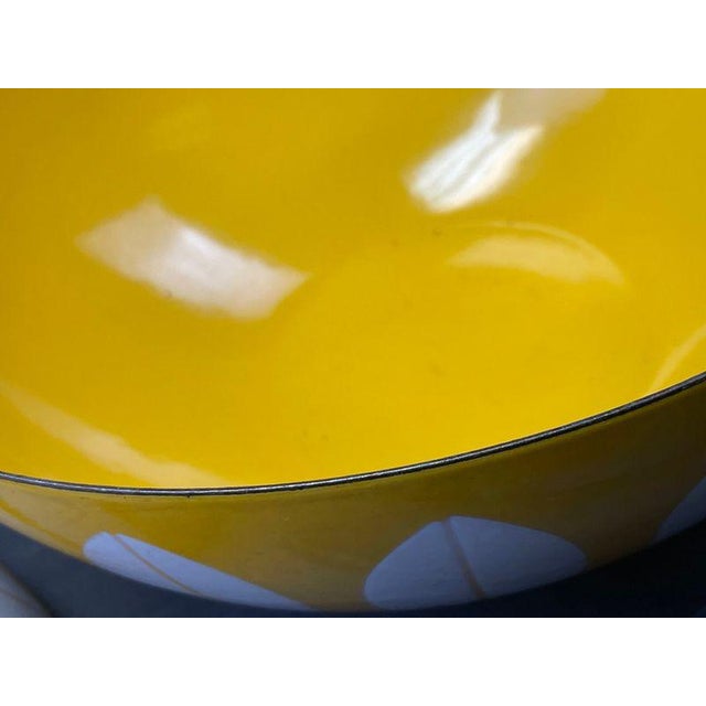 Charming set of mid-century modern yellow enamel nesting bowls. These vibrant bowls feature a bright yellow exterior with...