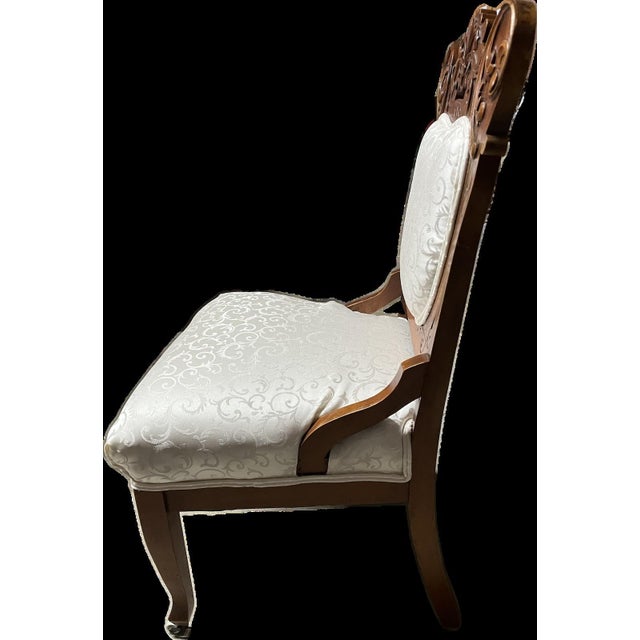 Eastlake Victorian Style chair. Intricately carvedi wood frame and new white scroll pattern fabric. Beautifully upholstered.