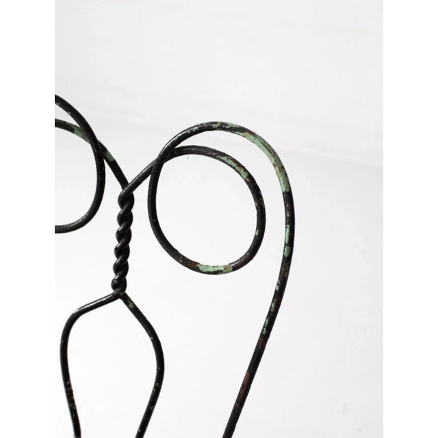 A vintage ice cream parlor chair. The black metal chair features a classic "spectacle" design back with a metal seat....