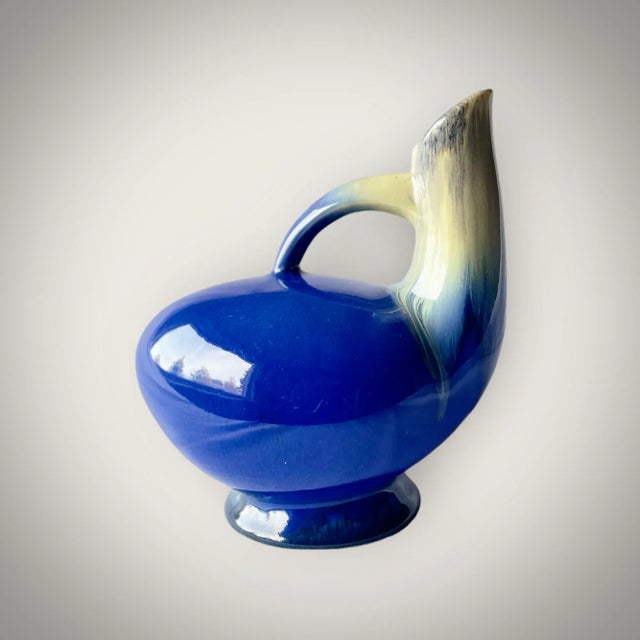 Unique vase with a graceful bird-like appearance. Blue with white tinting at the neck. Designed and manufactured by the...
