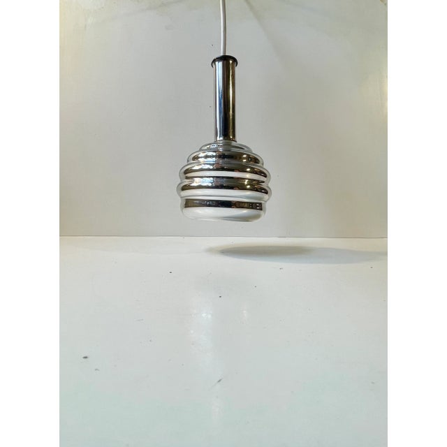 Unusual possibly bespoke small Italian hanging light in fluted mirror glass and tubular chrome-plated steel. Its design...