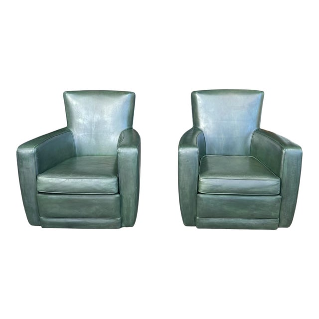 This striking pair of swivel lounge chairs showcases bold sculptural lines paired with rich, custom-dyed leather....