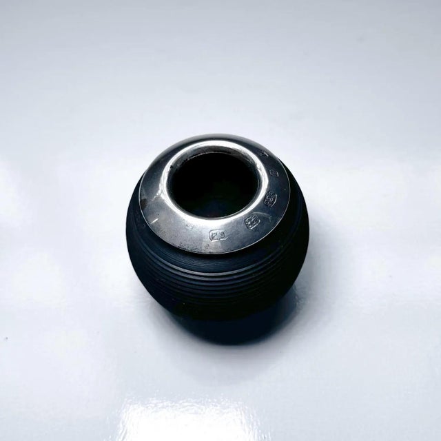 A finely crafted antique match striker featuring a ribbed ebony wood body paired with a sterling silver rim. This classic...