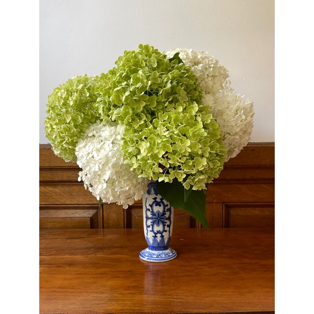 Uniquely shaped blue and white glazed vase. Its shape - tall, narrow, and oval shaped opening up at the top rim - creates...