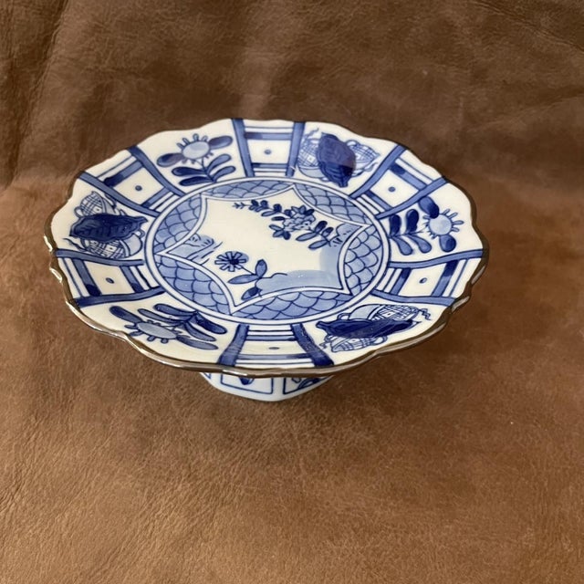 Two blue-and-white porcelain dish on a pedestal, shaped like a petal and decorated on the inside with blue-and-white...