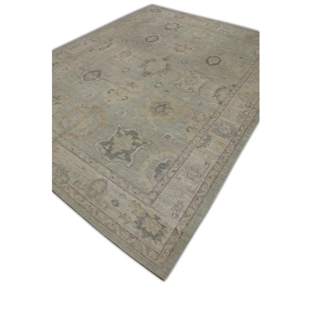 This modern Turkish Oushak rug is a stunning piece of art that has been handwoven using traditional techniques by skilled...