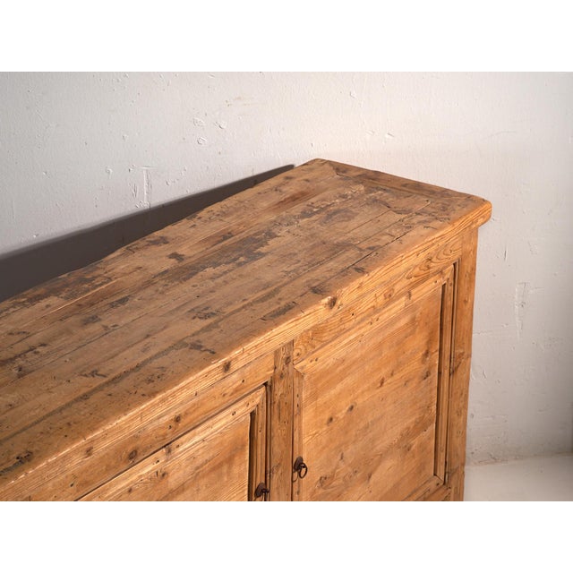 Antique wooden sideboard with three doors (c.1920) Approximate age: 100 years Material: Pine Our wooden sideboard is a...