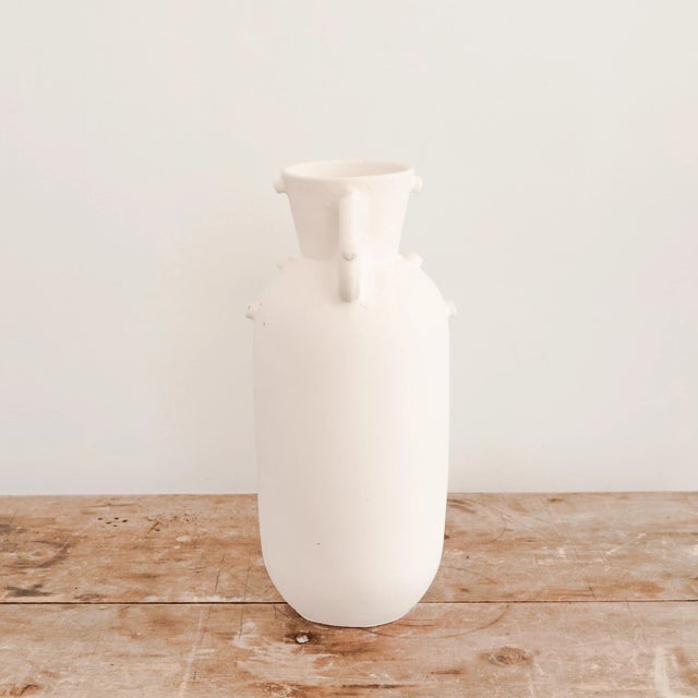 Unglazed white ceramic Miku vase with handles.