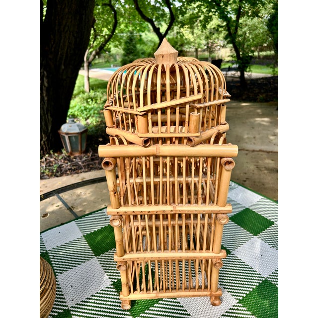 A charming vintage rattan and bamboo wine rack designed to hold up to twelve bottles, featuring two decorative domed tops...