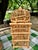 A charming vintage rattan and bamboo wine rack designed to hold up to twelve bottles, featuring two decorative domed tops...