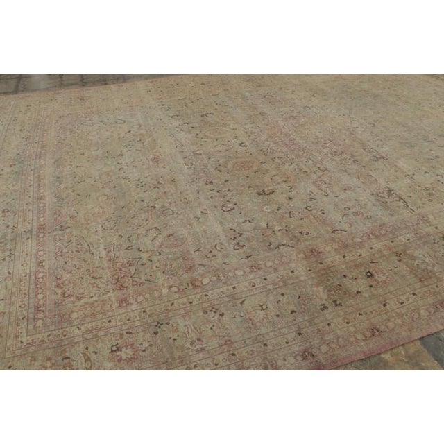 Hand-knotted in wool and originating circa 1890-1910, this 12x17 antique Persian Mashad rug is an exceptional example of...