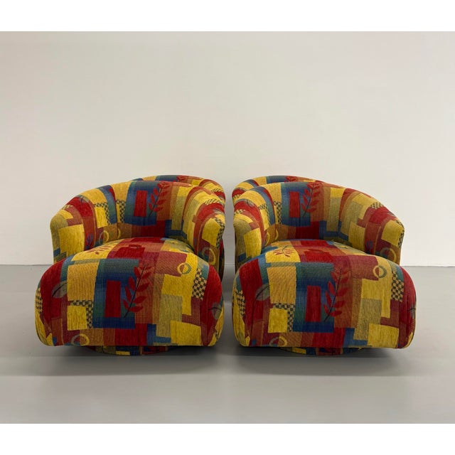 A sculptural set of vintage swivel lounge chairs featuring an oversized barrel-back silhouette and fully upholstered form....