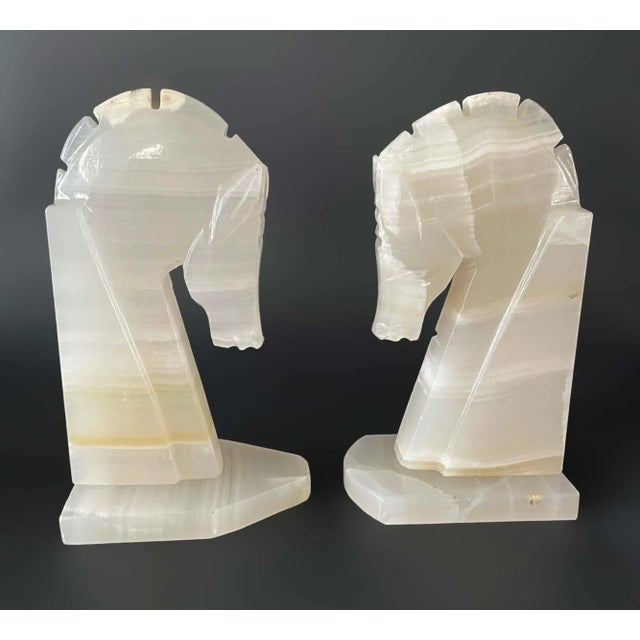 Pair of carved onyx bookends with horse motif. Some wear, bases are different shapes.