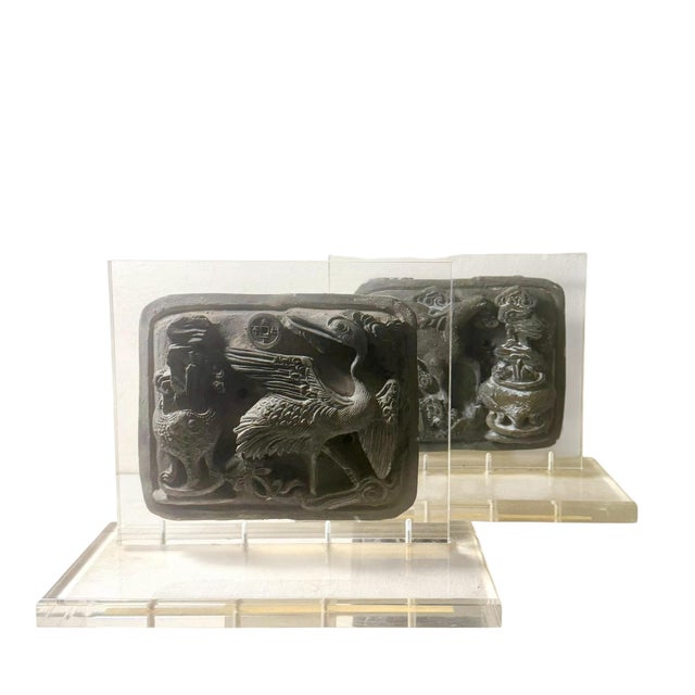 A striking pair of early Chinese carved stone reliefs, each mounted on bespoke lucite stands with elegant beveled edges,...