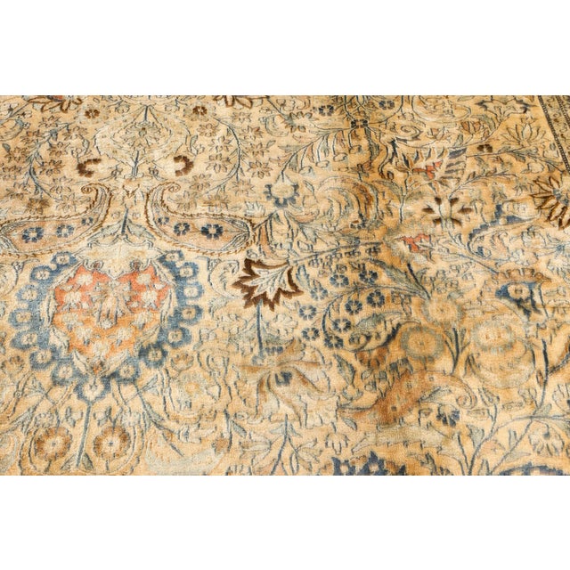 An early 19th century Mashad Persian rug, the camel field with an expressive trellis overall of palmettes, botehs and...