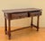 Elegant Spanish console table crafted in walnut and featuring two richly carved drawers with striking geometric motifs and...