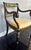 Elegant Hollywood Regency–style accent armchair featuring a classic Sheraton-inspired silhouette with an ebonized (black)...