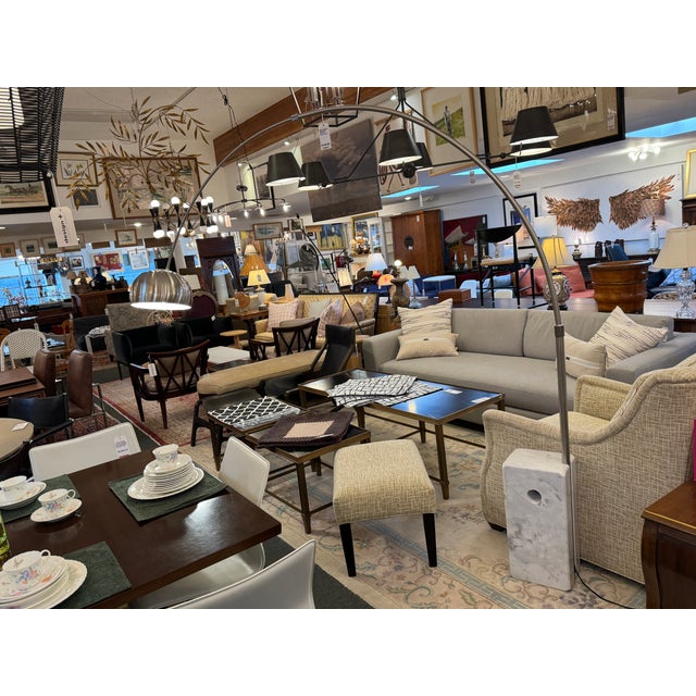 Design Plus Gallery presents an Arching Floor Lamp with Mid-Century Style. The floor lamp has a curved metal arm, a dome-...