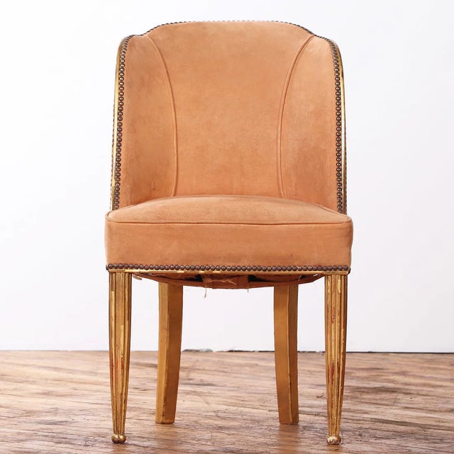 An elegant French giltwood accent chair dating to circa 1930, embodying the refined restraint and quiet luxury of early...