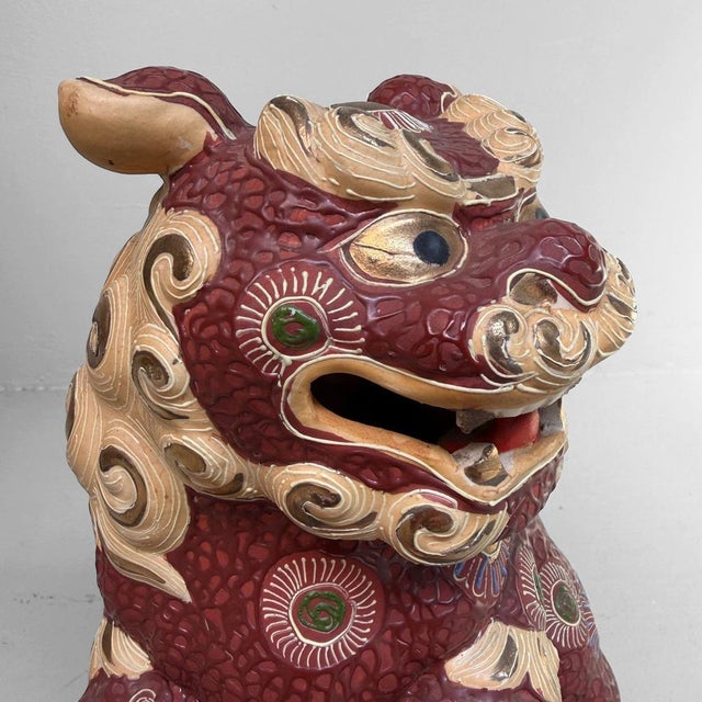 A refined Japanese Kutani shishi, richly decorated with red glaze, gilt accents, and colourful enamelled patterns....