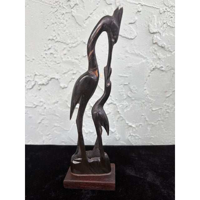 This captivating vintage sculpture depicts a tender scene of a mother crane feeding her young, beautifully carved from...