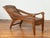 An antique Indonesian reclining plantation lounge chair with bamboo slats and carved motifs. Designed to provide a...