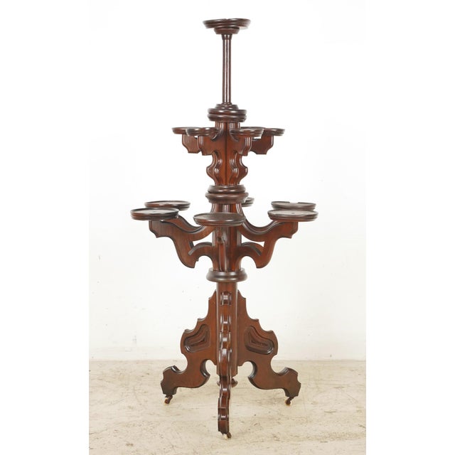 Antique Victorian large freestanding plant stand in dark wood tones, with fretwork detailing. Each tier can spin, and the...