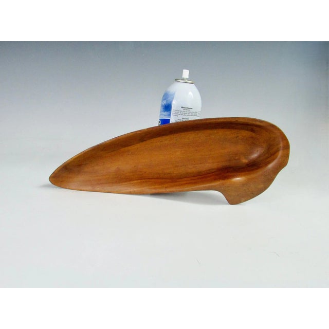 A long rare hand-carved wood bowl with an indented rim, from the "Oceana" series . Branded " Russell Wright " and retains...