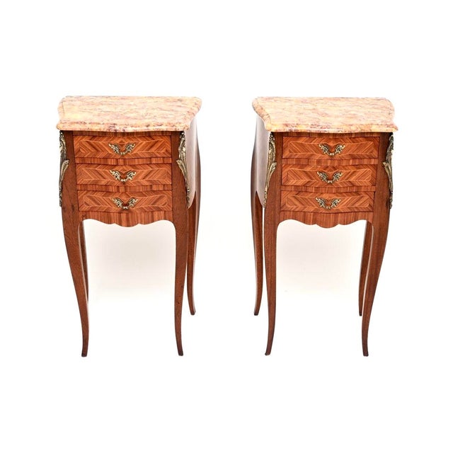 A stunning pair of antique French inlaid parquetry marble top bedside chests. They were made in France and date from...
