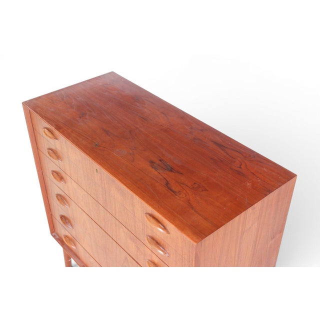 A superb 1960s Danish teak highboy dresser by Johannes Sorth for Nexø Møbelfabrik, featuring the celebrated "orange slice"...