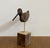 Bring a touch of coastal serenity and rustic texture into your space with this captivating hand-carved shorebird...