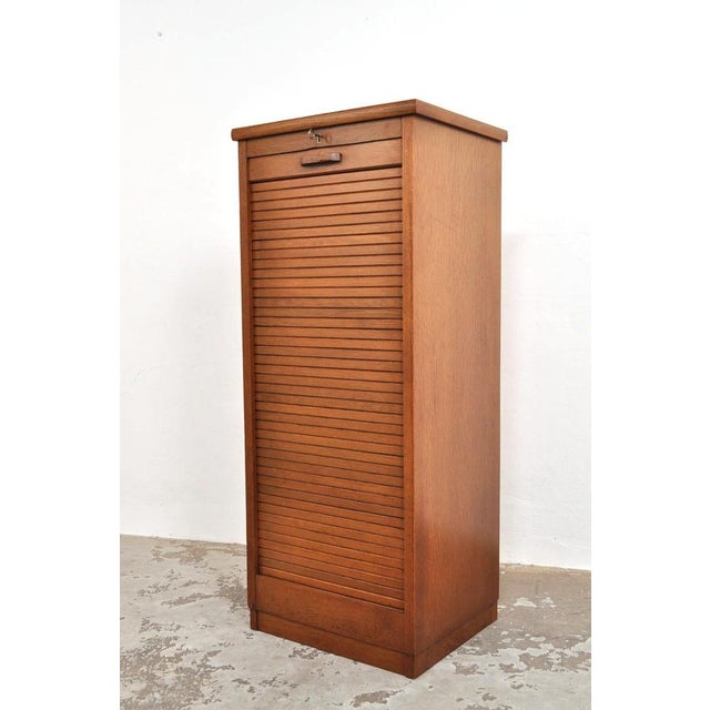 Despite its age, it is still in excellent condition. The oak cabinet features a smoothly operating roller door, a working...