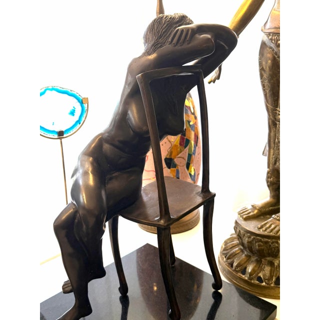 Mid 20th Century artist executed bronze of a female figure splayed on a chair. Mounted on a black stone base. Attributed...