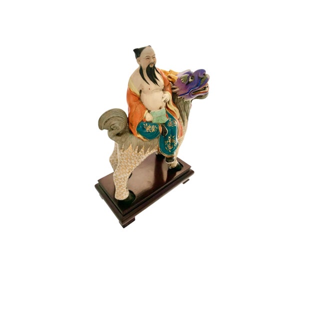 Vintage Asian decor piece of Chinese immortals riding a dragon on wooden base. Ornate folk-art craftsmanship. Condition:...