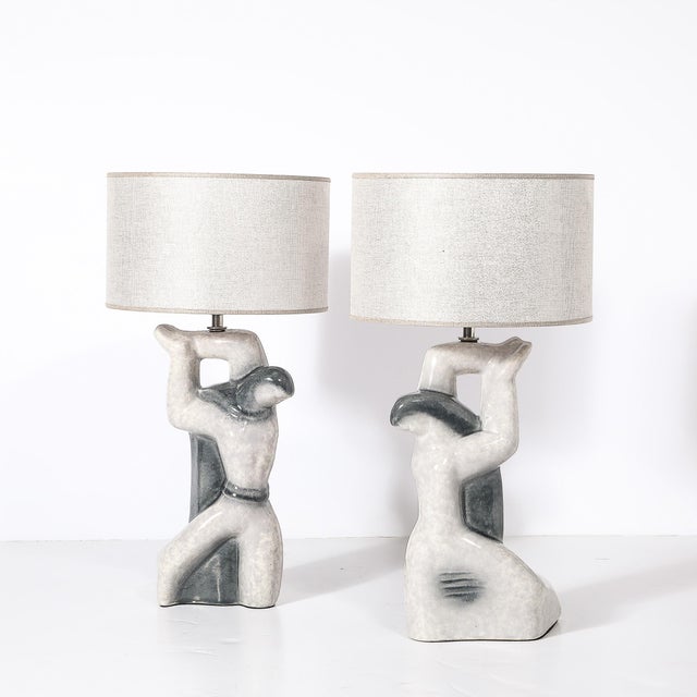 This striking pair of Mid-Century Modernist ceramic table lamps showcases an abstract figural design that embodies the...