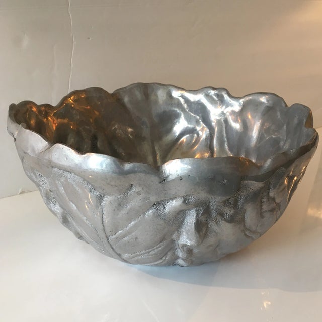 Great heavy metal bowl with textured leaves on the outside. It appears to be handmade as there are no mold markings on it....