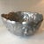 Great heavy metal bowl with textured leaves on the outside. It appears to be handmade as there are no mold markings on it....