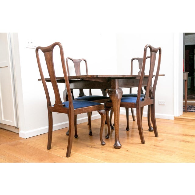A small vintage Queen Anne style extendable dining table with elegant cabriole legs and two extension leaves and four...