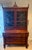 Early 1900s flame mahogany secretary featuring an upper bookcase with mullioned doors, adjustable shelving, pen and pencil...