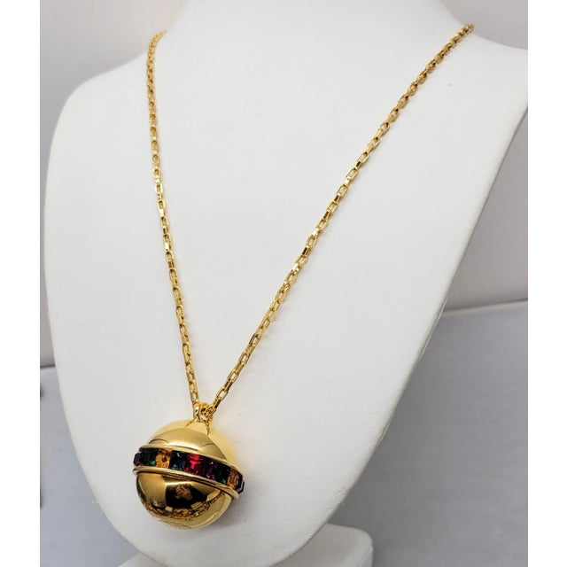 Early 1990s goldtone spherical pendant with a line of square cut faux-citrine, faux-sapphire, faux-garnet, faux-amethyst...