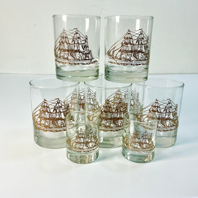 This set of 7 Lowball Whiskey Glasses feature a raised Bronzed-Gold colored Tall Mast Ship. The set also has 2 Shot...