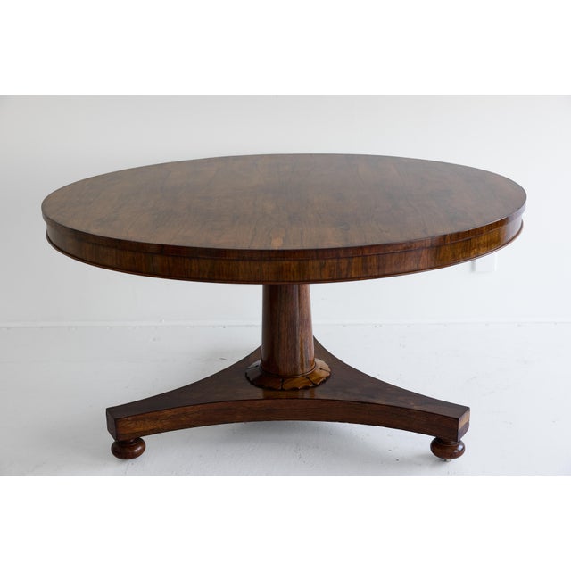 A handsome 19th Century English William IV center table in richly figured rosewood, combining the bold architectural forms...